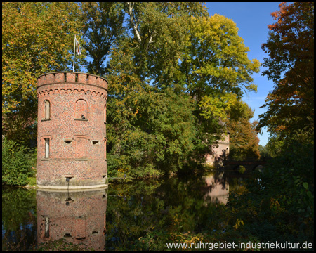 In der Gräfte spiegelt sich ein runder Turm