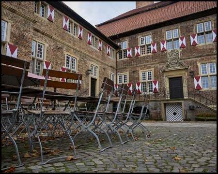 Stühle einer Außengastronomie auf einem Schlosshof