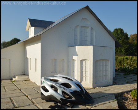 Weberhaus mit Fahrradhelm als Größenvergleich