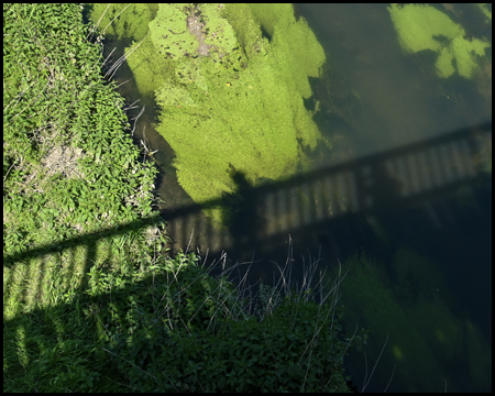 Schatten einer Brücke auf einem Fluss