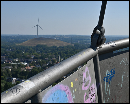 Aussicht auf eine Ebene mit der Mottbruchhalde mit Windrad