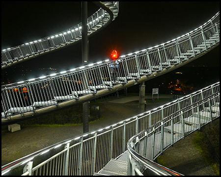 Mehrere Treppen hinter- und übereinander mit beleuchtetem Geländer als Teil der Achterbahn im Angerpark