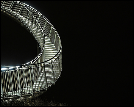 Eine beleuchtete Treppe in absoluter Dunkelheit