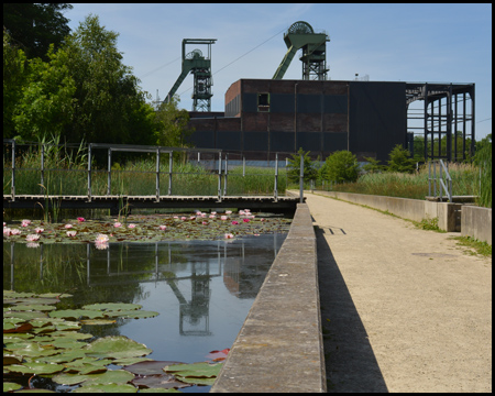 Fördertürme, die sich im Seerosenbecken spiegeln