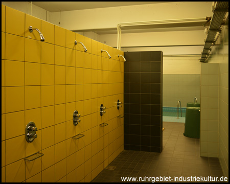Duschen mit Fliesen in Vereinsfarben, hinten Entmüdungsbecken