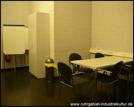Trainerraum für Taktik-Besprechungen mit Tisch,  Schreib-Board und gelben Müllsäcken