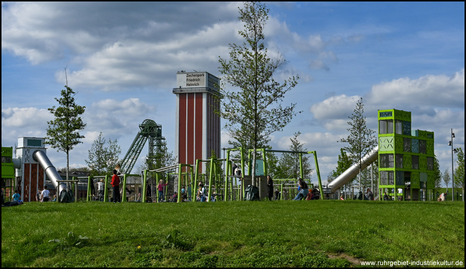 Spielplatz mit Nachbauten von Fördertürmen mit den entsprechenden Vorbildern im Hintergrund