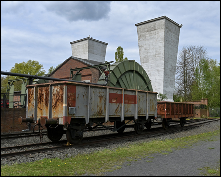 rostige Waggons vor einem Lüftergebäude einer Zeche