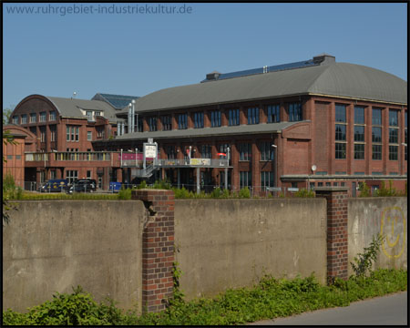 Blick über die Mauer: Kauengebäude mit Kletterzentrum