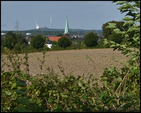 Ausblick auf eine Siedlung mit Kirche und Kraftwerk