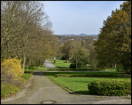 Aussicht von einer Grünanlage in eine Ebene mit einer Halde am Horizont